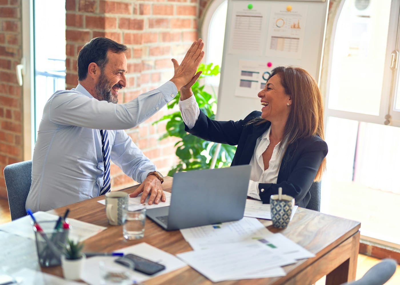 Two colleagues celebrating at their desk